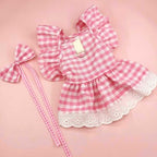 Sweet pink gingham dog dress with eyelet lace trim, ruffled sleeves, back bow, and matching leash.