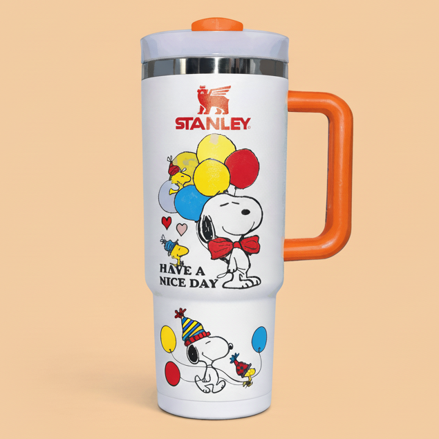 Stanley travel mug with Snoopy and Woodstock design having a bright orange handle and lid