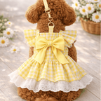 Small dog wearing sunny yellow gingham dress with eyelet lace trim, ruffled sleeves, and built-in D-ring leash attachment.