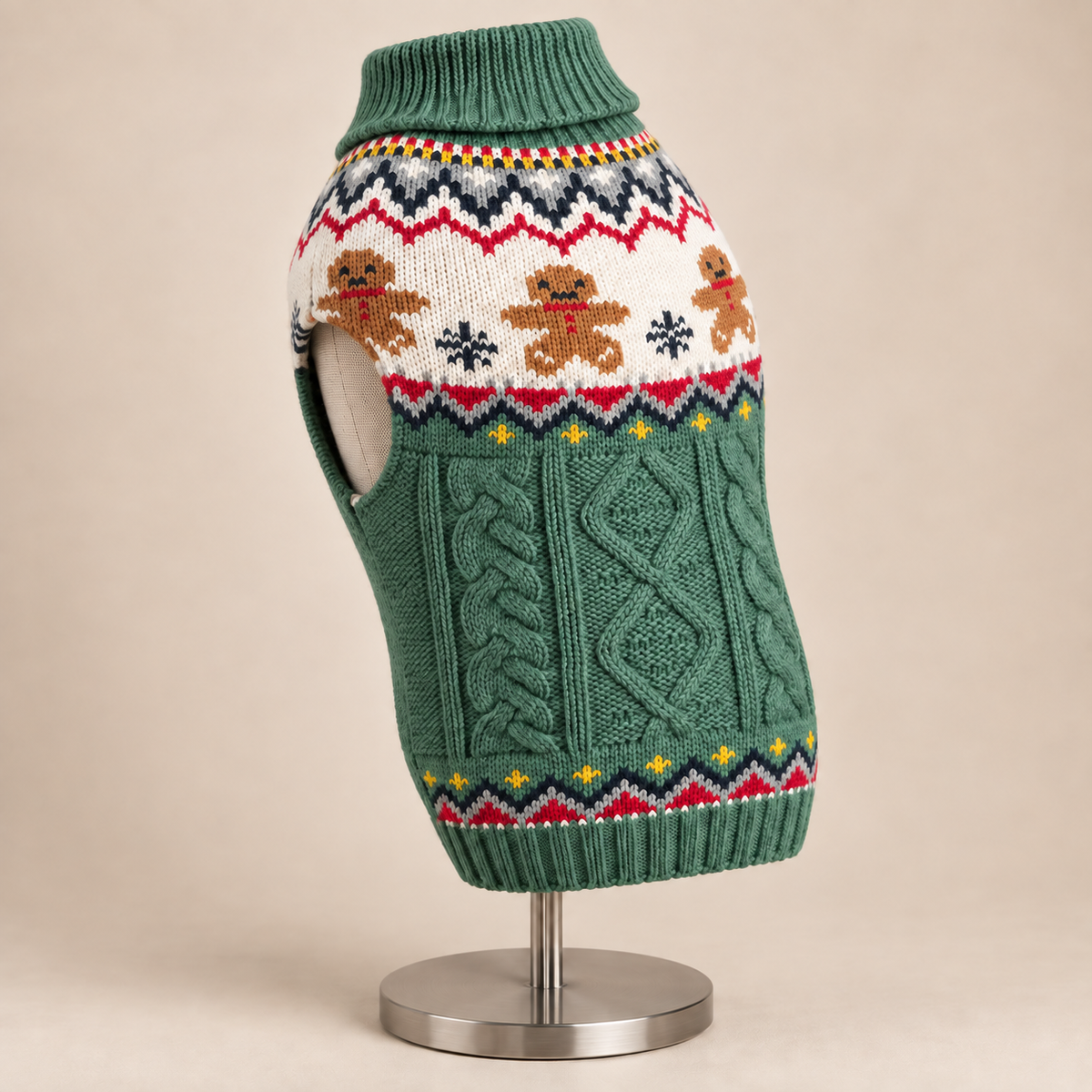 A green knit dog sweater with a festive fair isle pattern featuring gingerbread men, snowflakes, and stars, displayed on a mannequin torso stand against a solid beige background.