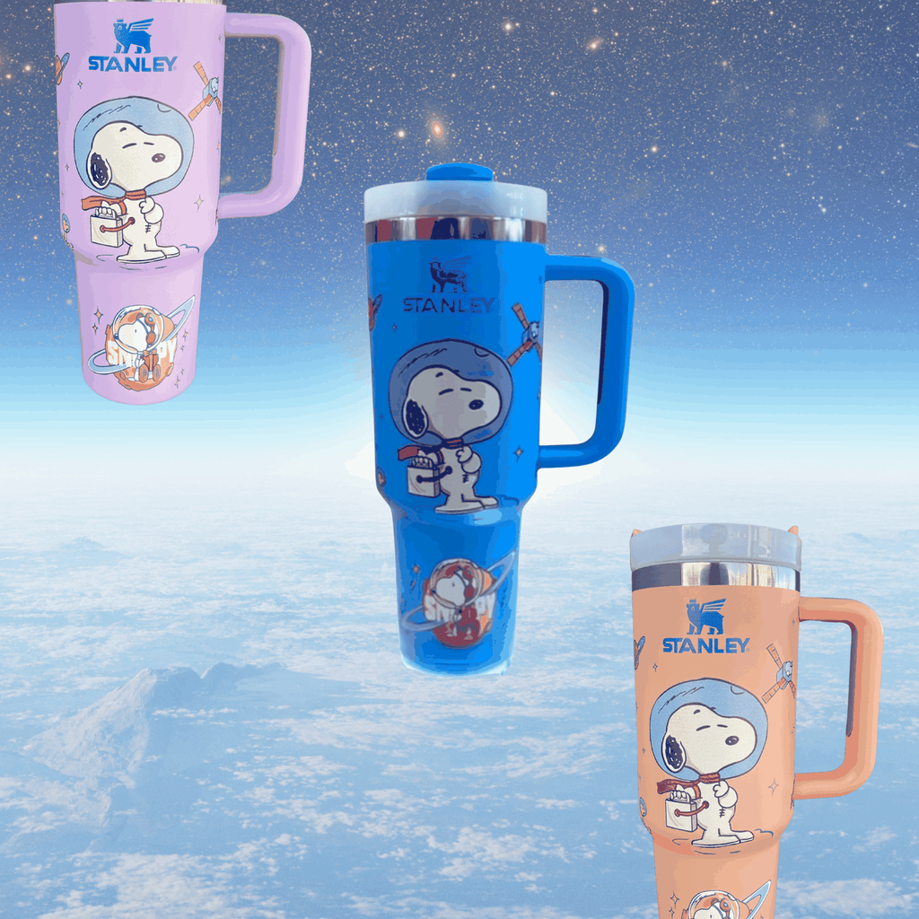Snoopy Space 40 oz tumbler with engraved space-themed Snoopy, handle, and clear lid in blue, purple, and peach colors