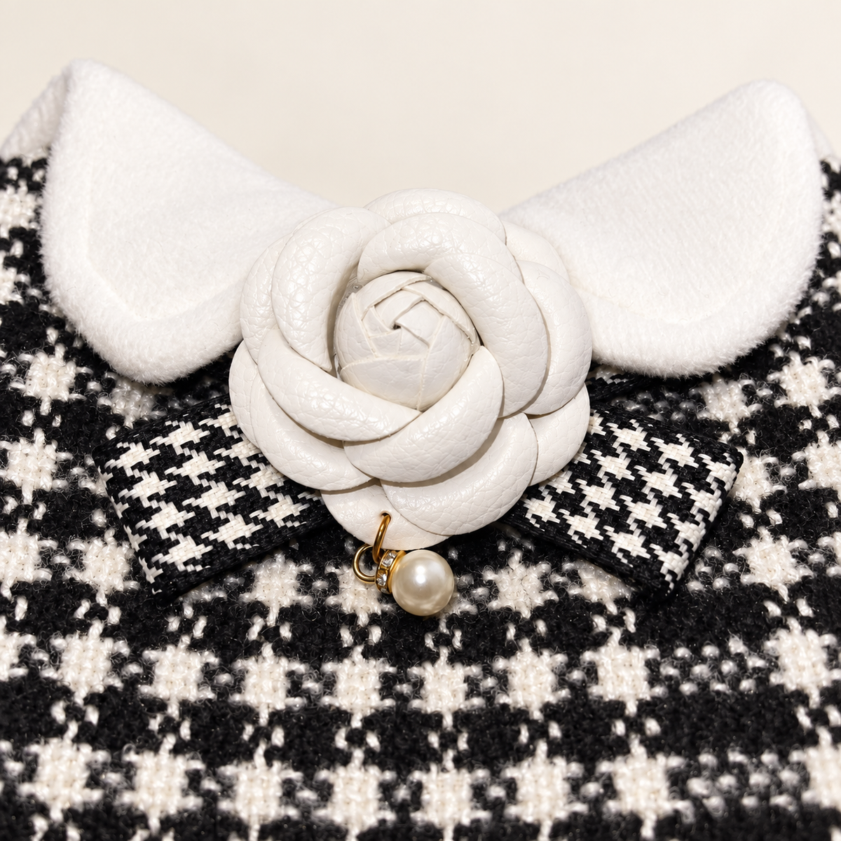 Close-up of white flower, pearl charm, bow and plush collar detail