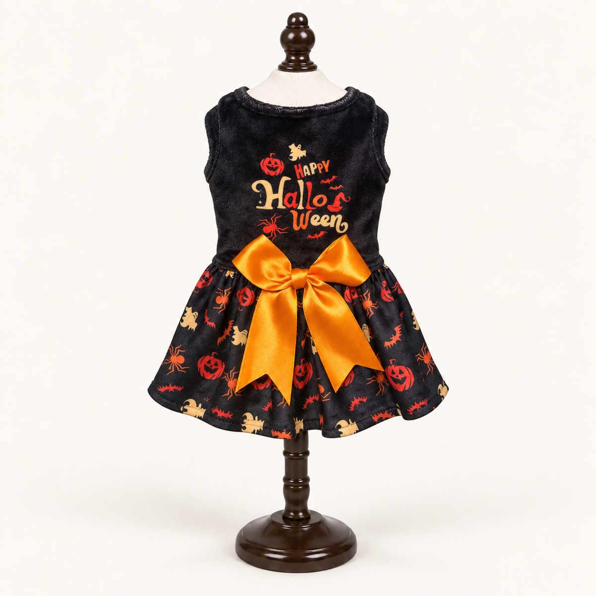 Back view of the Happy Halloween Bow dog dress displayed on an espresso catalog stand
