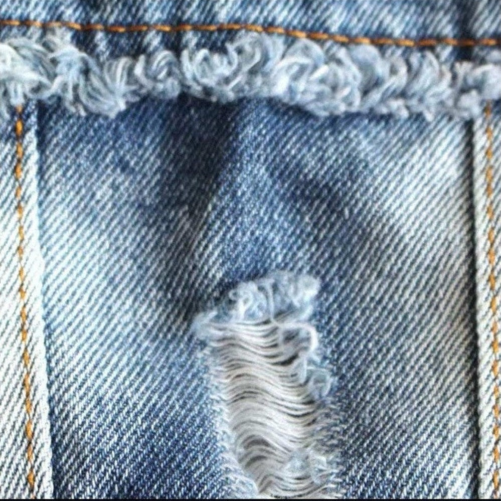 Close-up of a blue denim fabric with frayed edges