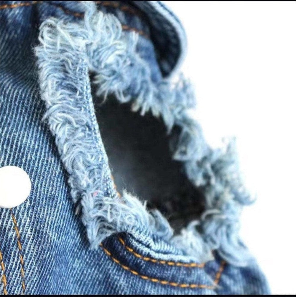 Close-up of a frayed denim edge with stitching details on a white background