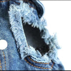 Close-up of a frayed denim edge with stitching details on a white background