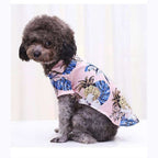 Small dog wearing blue Hawaiian tropical shirt with beach print design