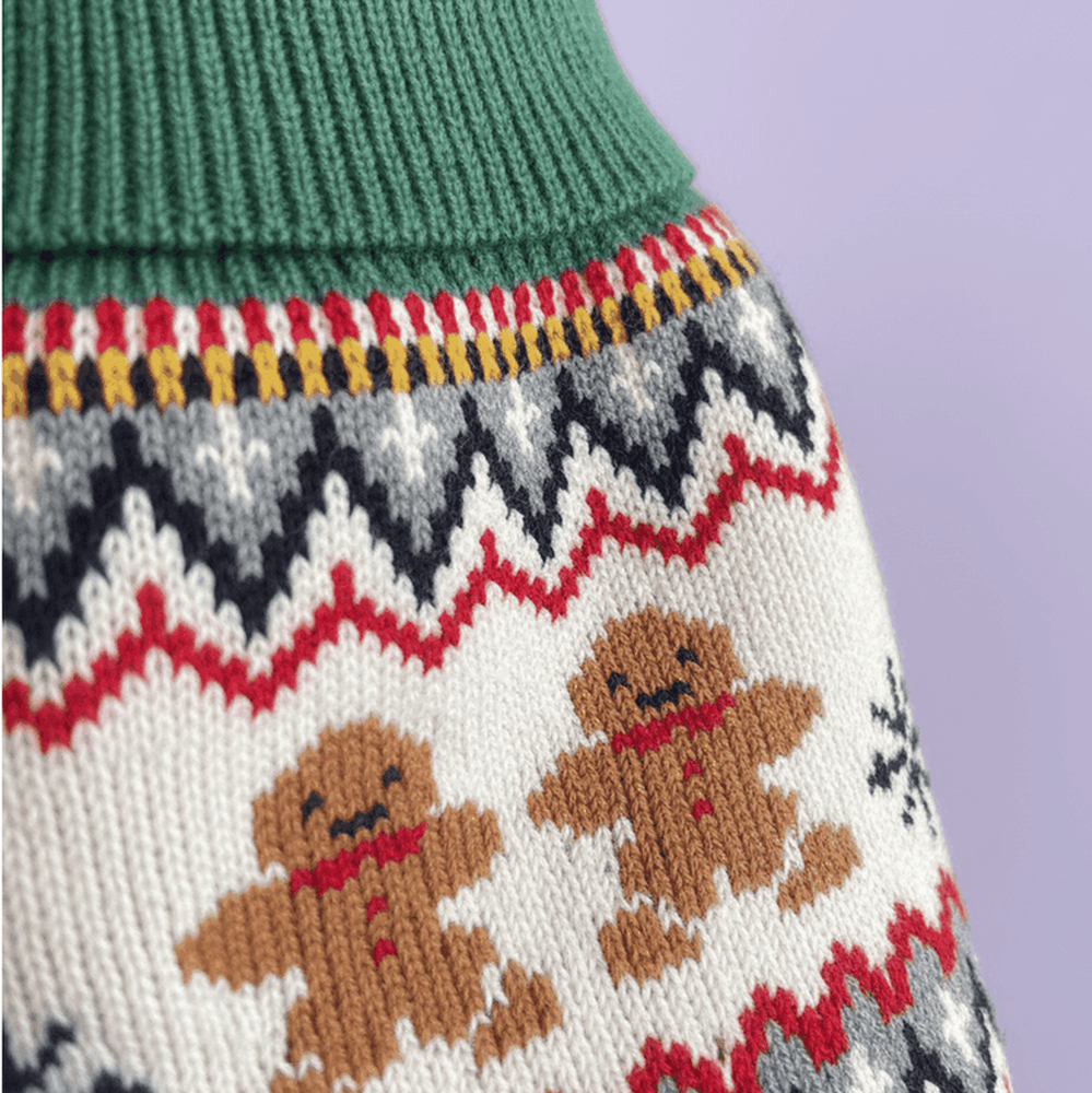 Close-up detail of gingerbread dog sweater showing Fair Isle knit pattern with gingerbread men, snowflakes and zigzag design on lavender background